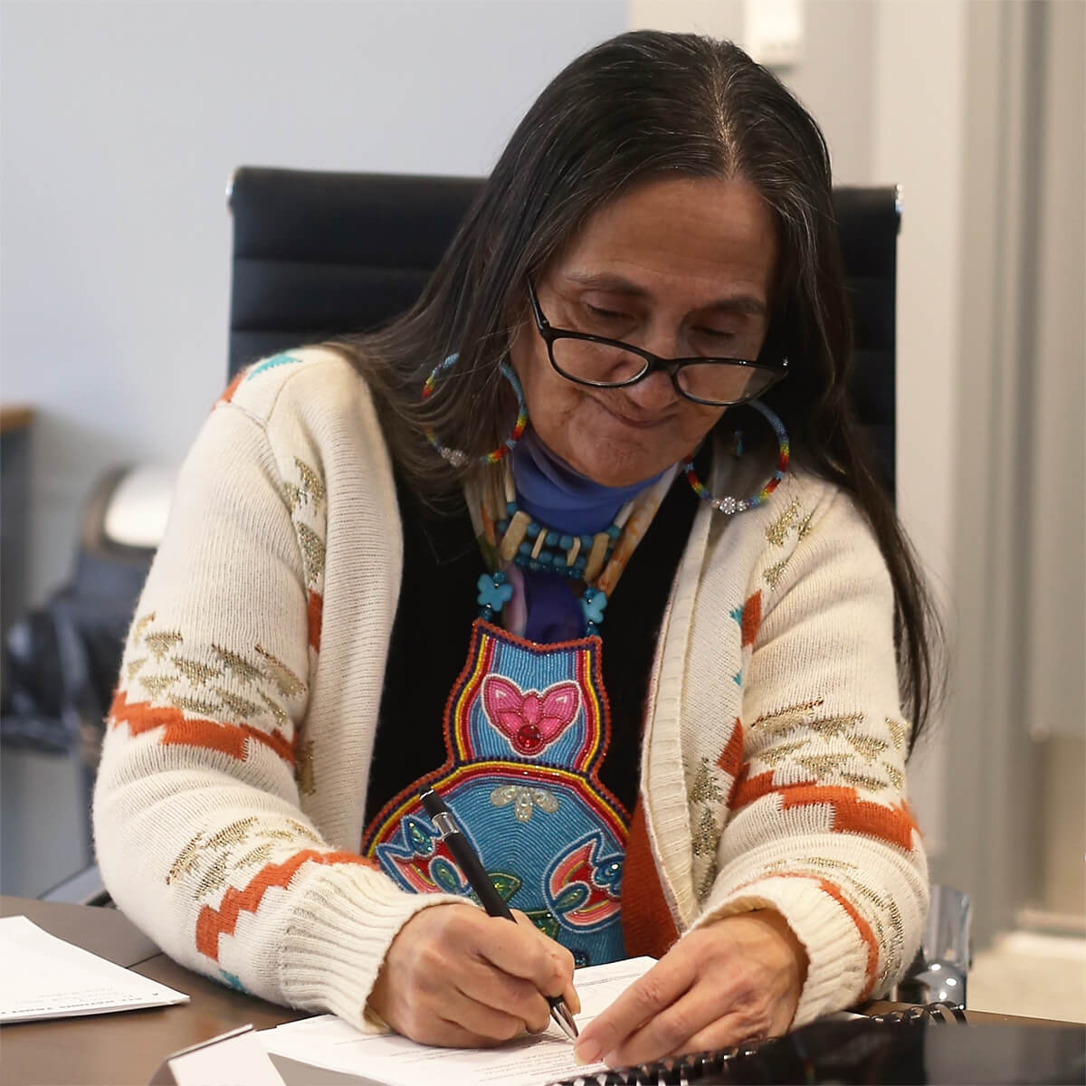 Sharon Kenoras, signing a document